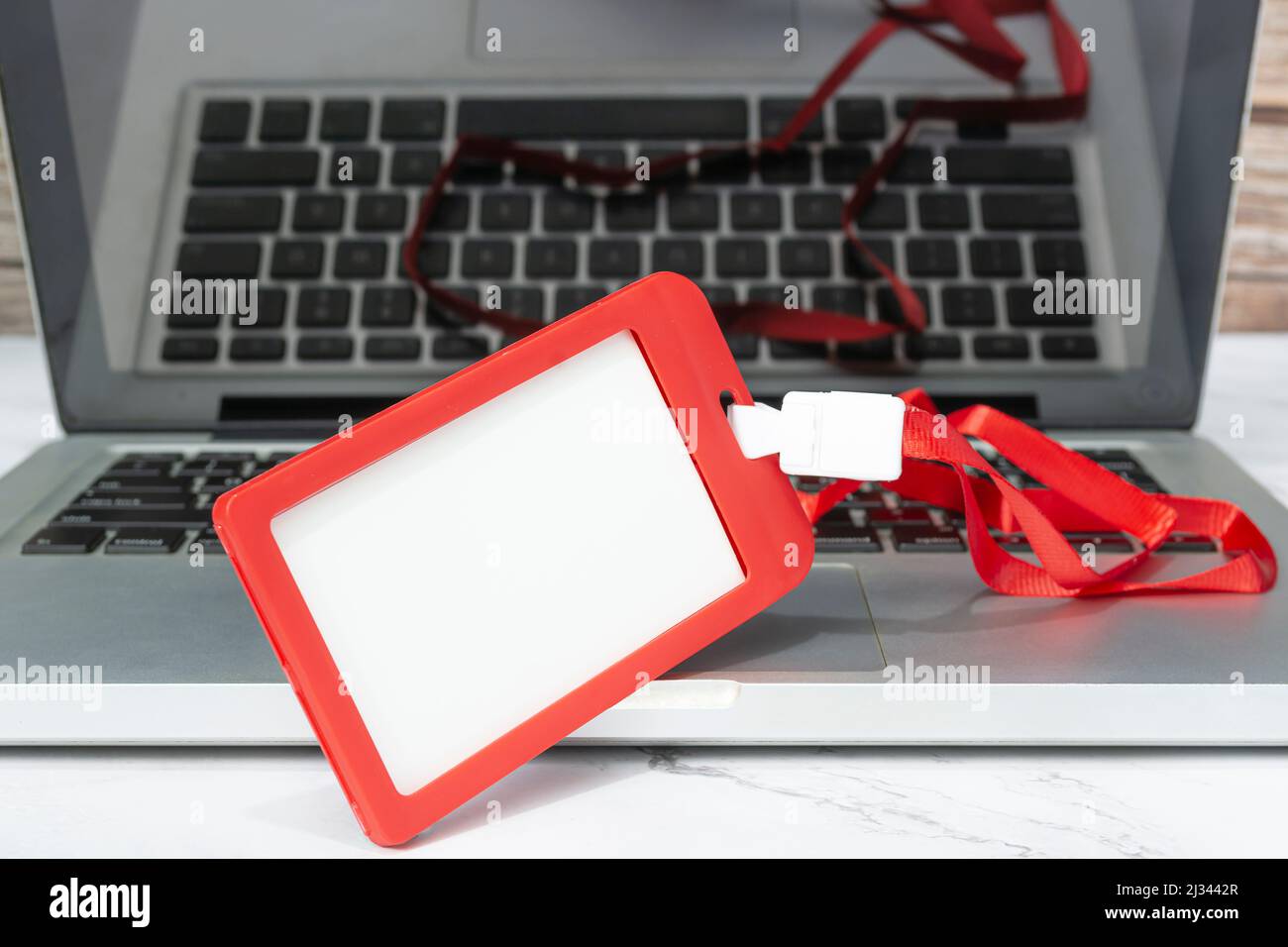 Red name tag placed on a laptop or notebook. Registration concept. Copy