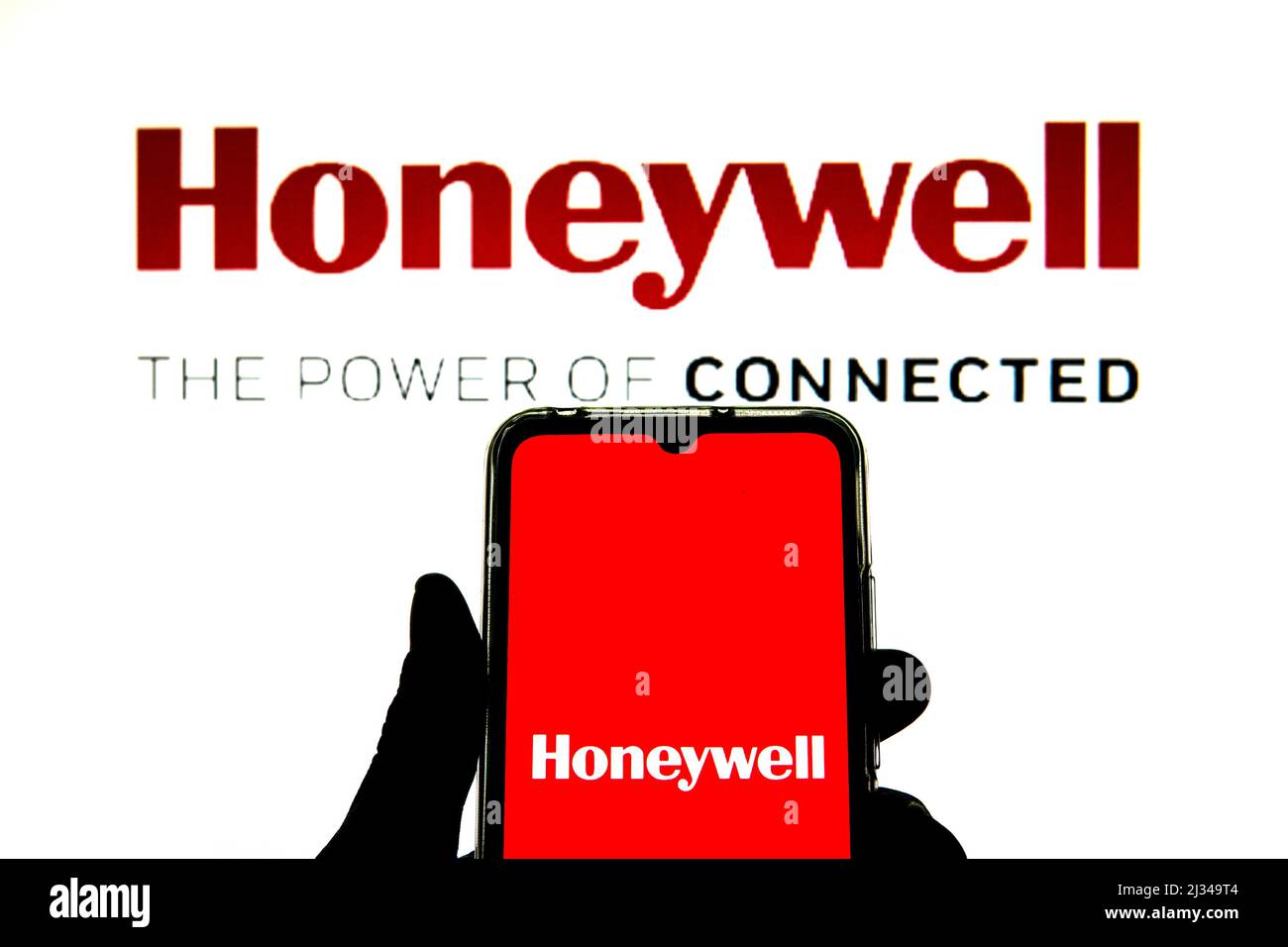 In this photo illustration a Honeywell International Inc. logo seen displayed on a smartphone with a Honeywell International Inc. logo in the background. Stock Photo