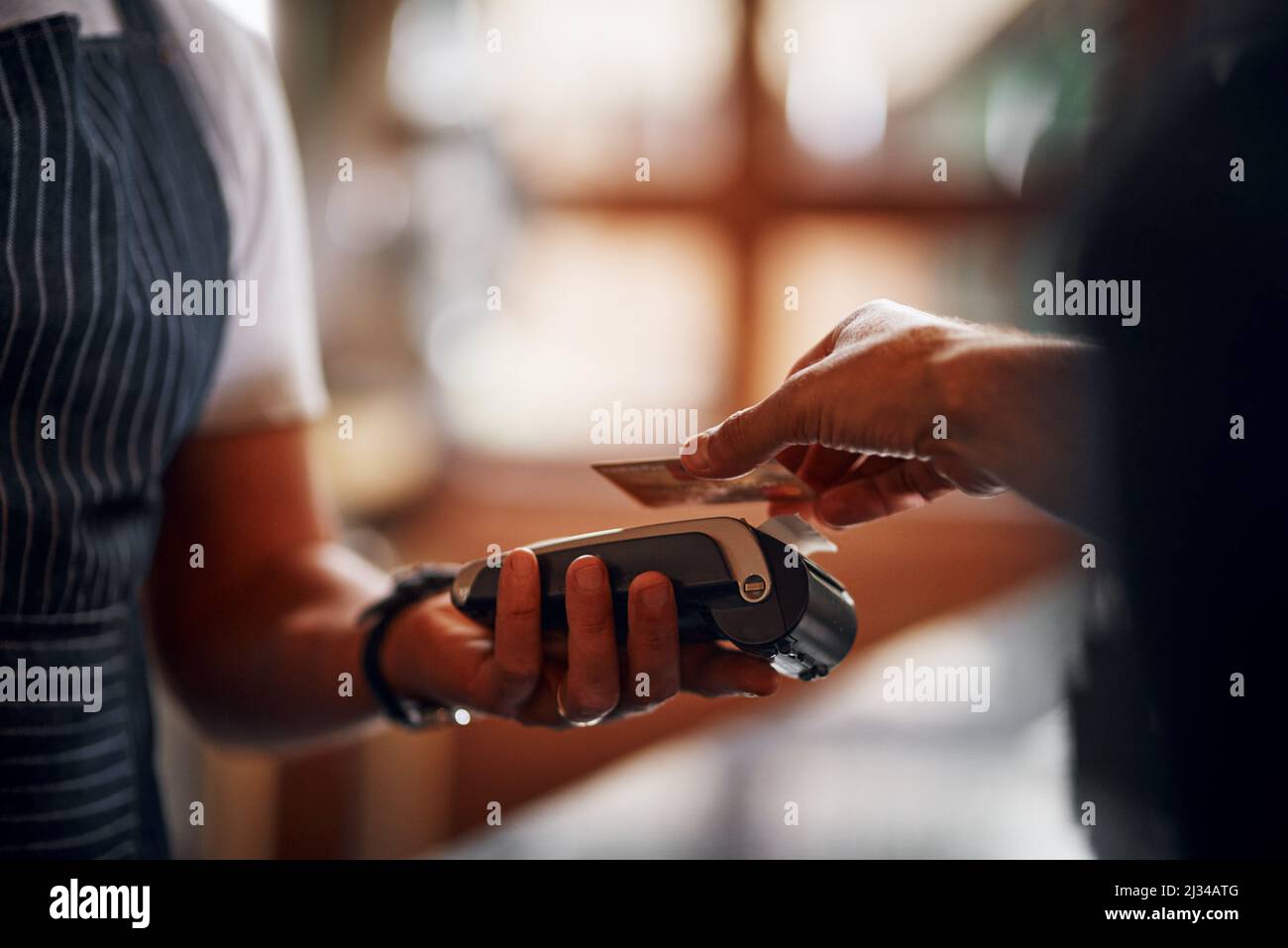 Very simple way of doing payments. Closeup of an unrecognizable person making a payment to a barman through use of a credit card inside a beer brewery Stock Photo