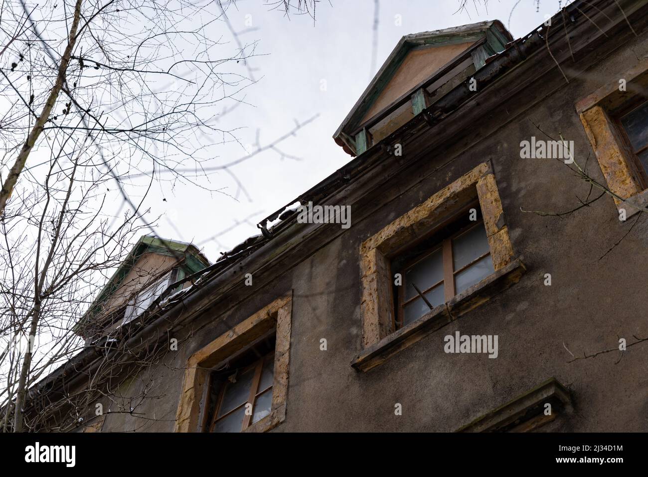 Abandoned building with a damaged facade and a broken window. Looking ...