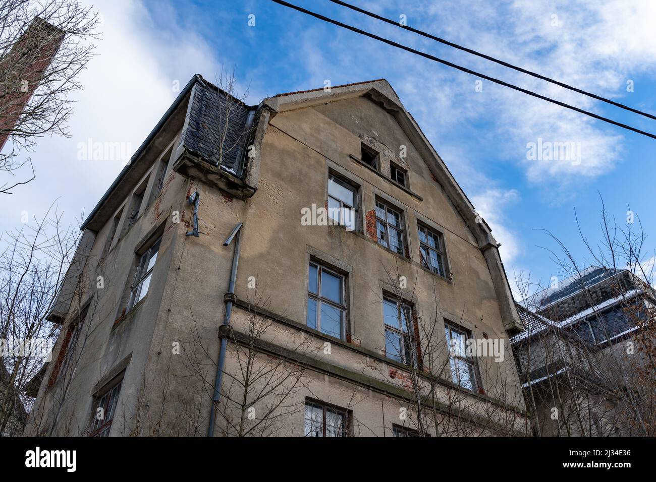 Abandoned building with a damaged facade and a broken window. Looking ...