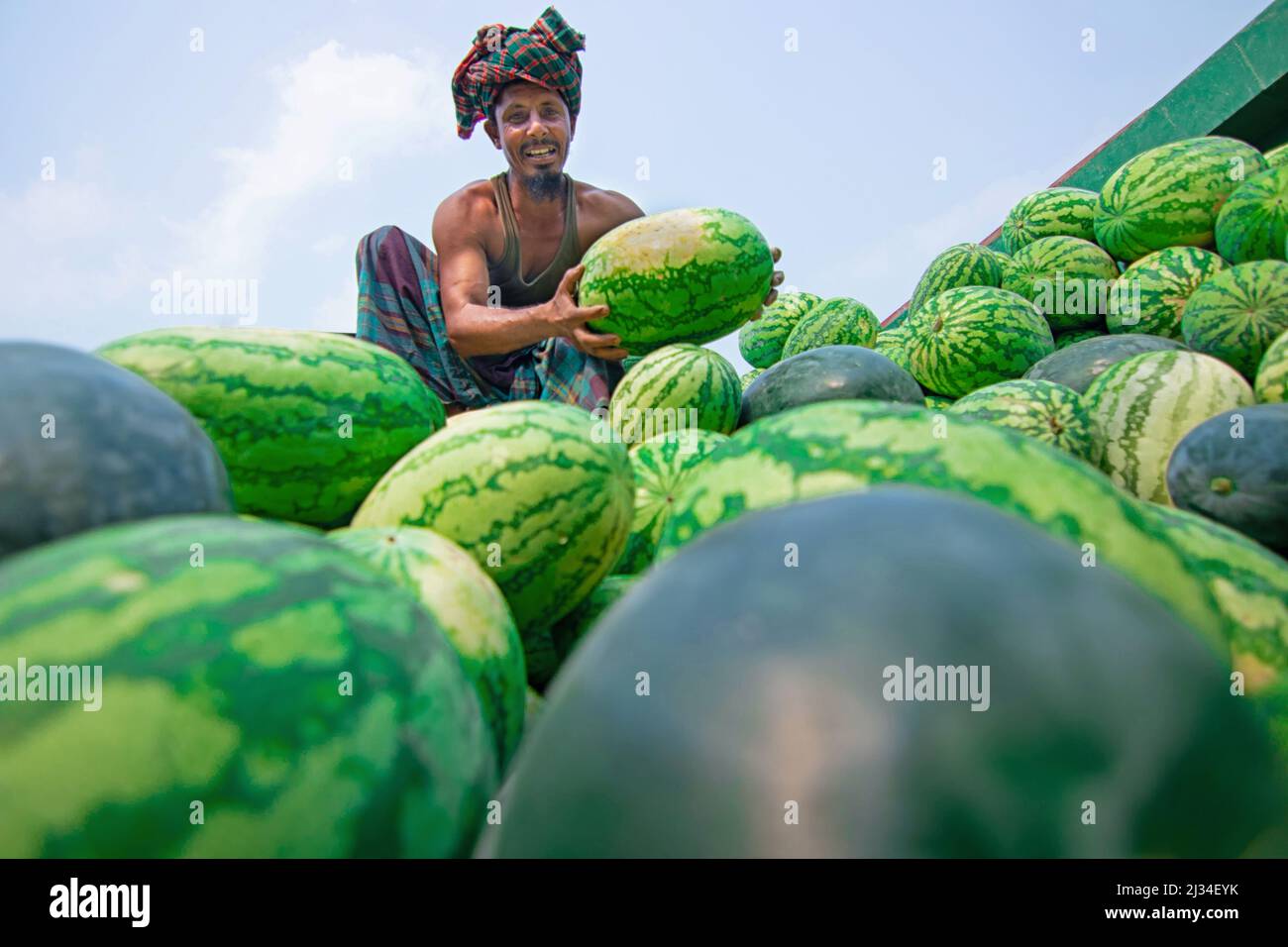 March 30, 2022, Narayanganj, Dhaka, Bangladesh: A seller displays watermelon  to attract the customers for sale at a bustling riverside wholesale fruit  market in Narayanganj, Bangladesh. Everyday, more than 50,000 watermelons  come