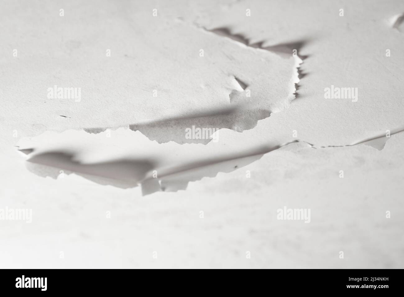 Damaged bathroom ceiling with cracked and peeling white paint on