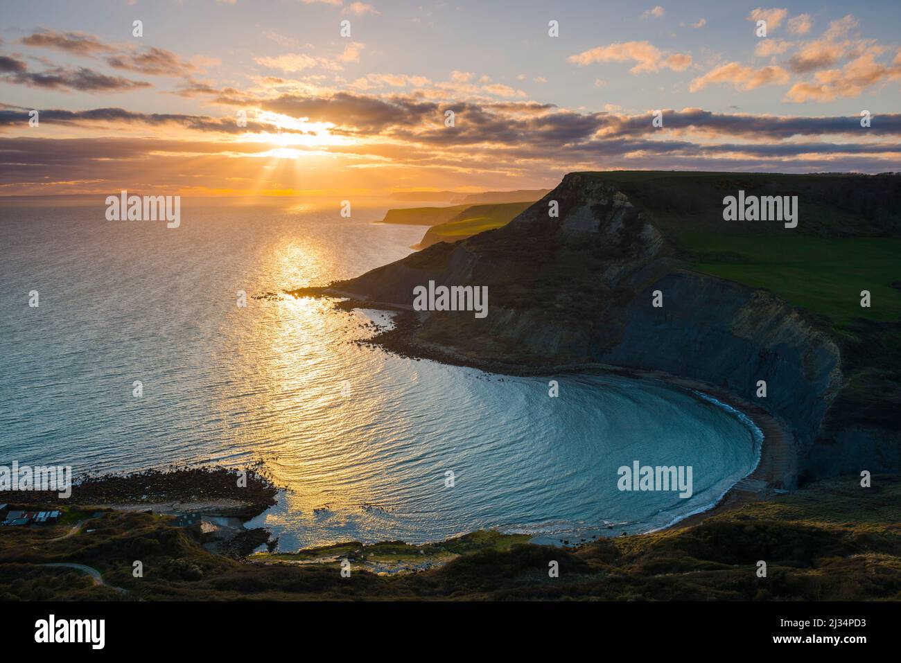 Worth Matravers, Dorset, UK.  5th April 2022.  UK Weather.  A dramatic sunset viewed from the South West coast path on Emmetts Hill looking across Chapmans Pool to the cliffs of Houns Tout on the Dorset Jurassic Coast near Worth Matravers at the end of a windy day with sunny spells.  Picture Credit: Graham Hunt/Alamy Live News Stock Photo