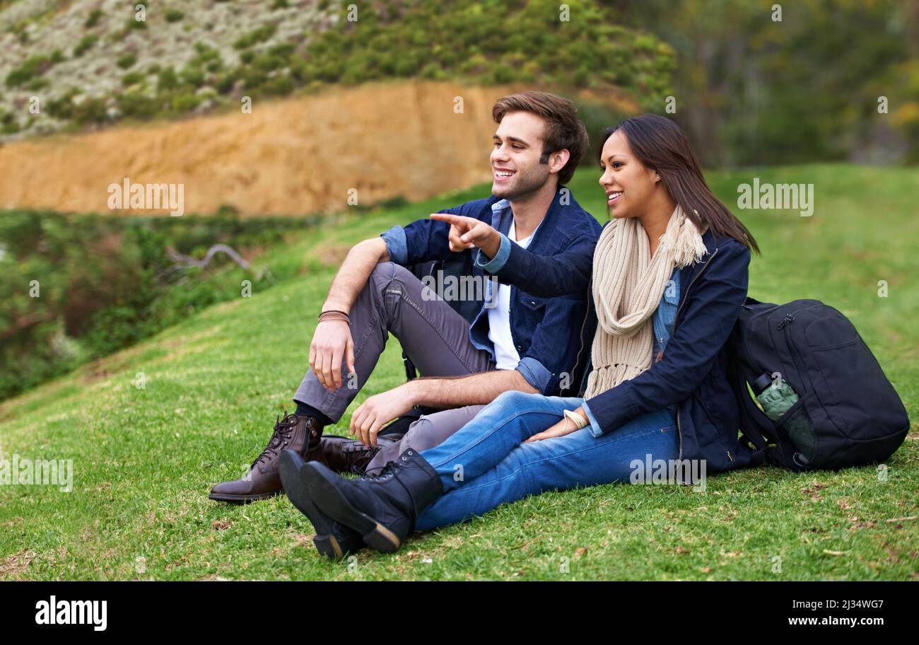 Is that view lovely. Shot of a good-looking young couple enjoying an affectionate moment outdoors. Stock Photo