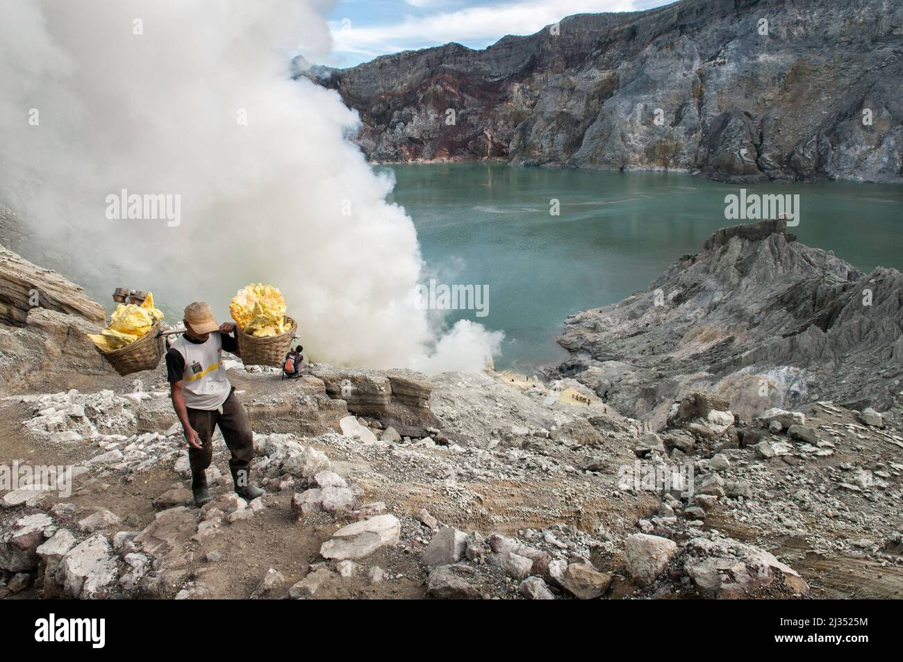 Miner carrying sulfur from the Ijen volcano crater, Java Island, Indonesia Stock Photo