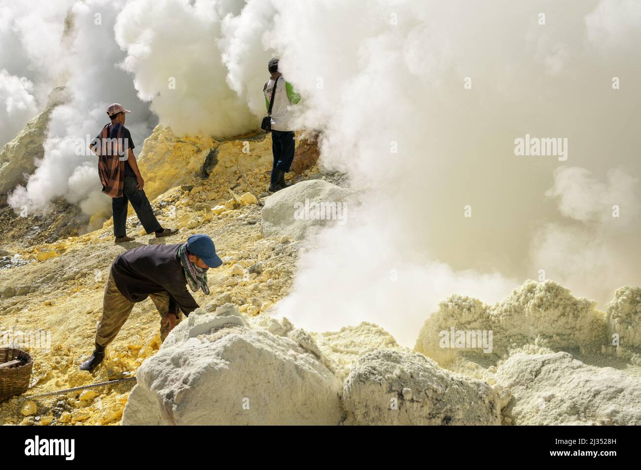 Sulfur miners working inside the crater of Ijen volcano, Java island, Indonesia Stock Photo