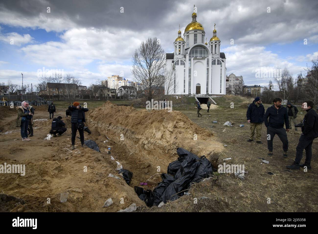 Bucha, Ukraine. 05th Apr, 2022. EDITORS NOTE - A mass grave is seen behind a church in the town of Bucha, northwest of the Ukrainian capital Kyiv, on Monday. April 4, 2022. Ukraine and Western nations accused Russian troops of war crimes after the discovery of the mass graves and civilians who were apparently executed near Kyiv. One rescue official said 57 people were found in one hastily dug trench behind a church. Photo by Vladyslav Musienko/UPI Credit: UPI/Alamy Live News Stock Photo