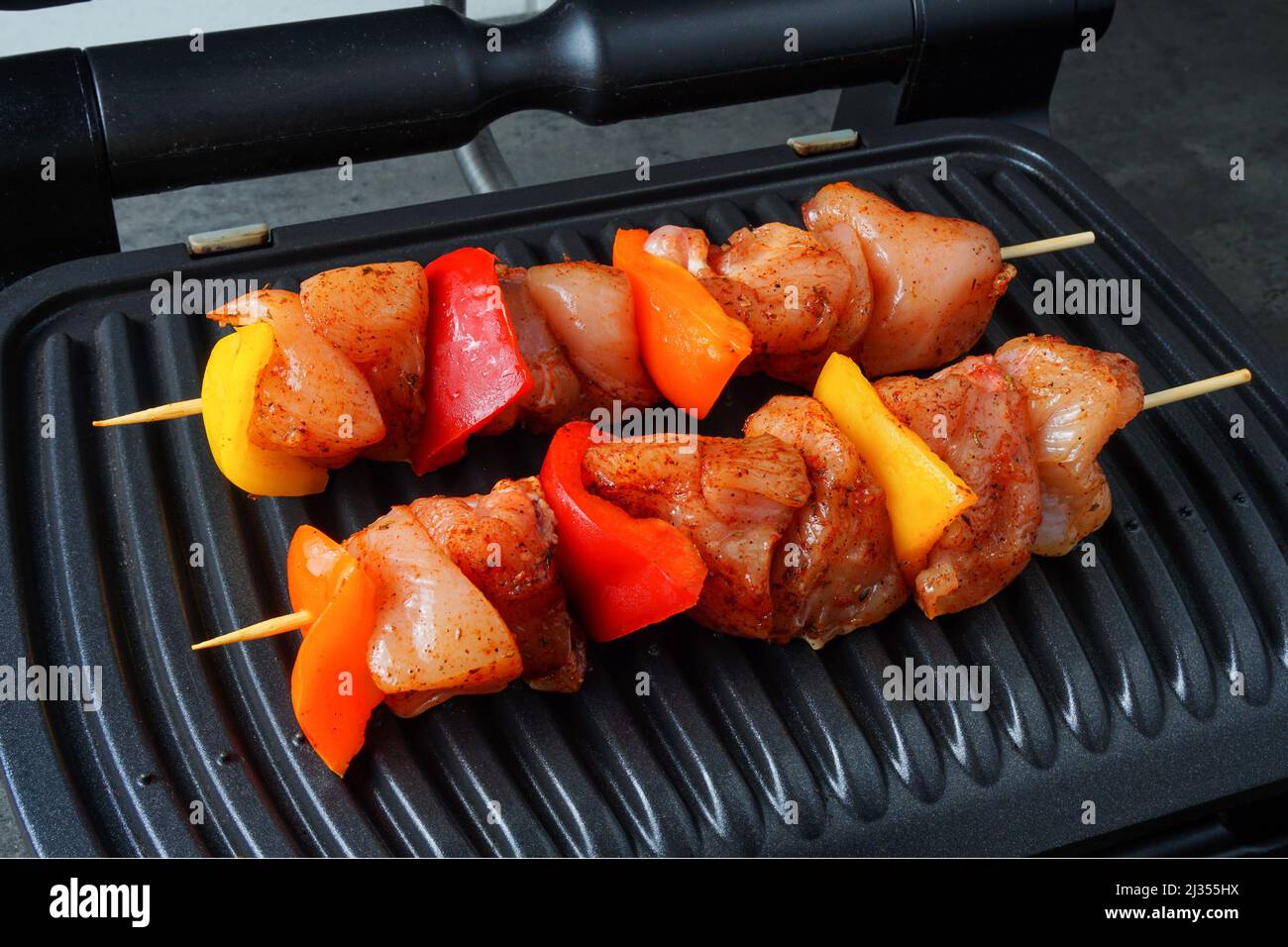 Chicken and vegetables skewers cooked on electric indoor grill. Stock Photo