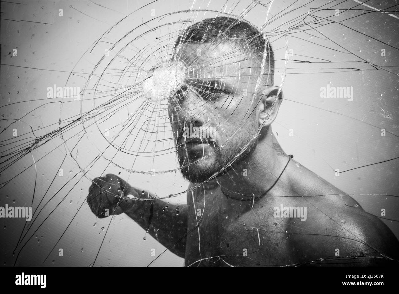Gangster man, cracked glass. Ready to fight. Man boxing, strength and power. Hispanic gang man, south american latin, criminal guy with serious face. Stock Photo