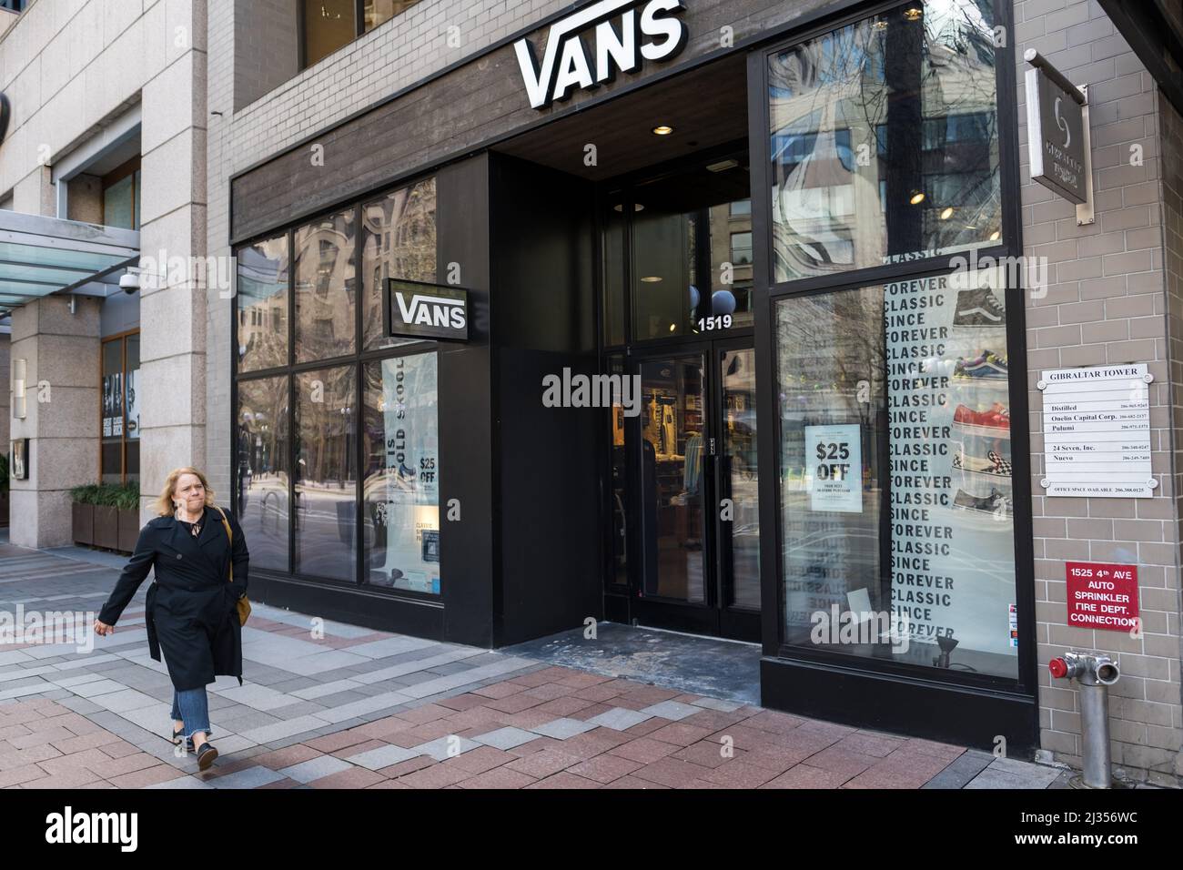 Seattle, USA. 5th Apr, 2022. A person passing the Vans store on 3rd and  Pine. The retail store is one of a handful of stores that have installed  ballistic riot proof glass.