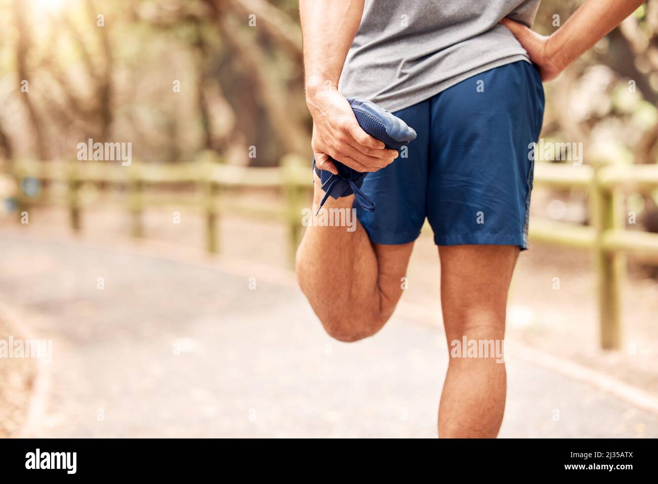 Exercising is safer with a warmup. Shot of an unrecognisable man stretching before her workout in nature. Stock Photo