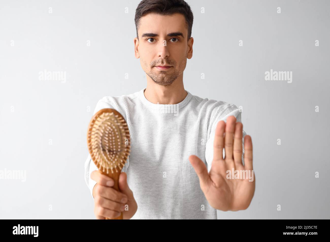 Handsome man with comb and fallen down hair showing stop gesture on ...
