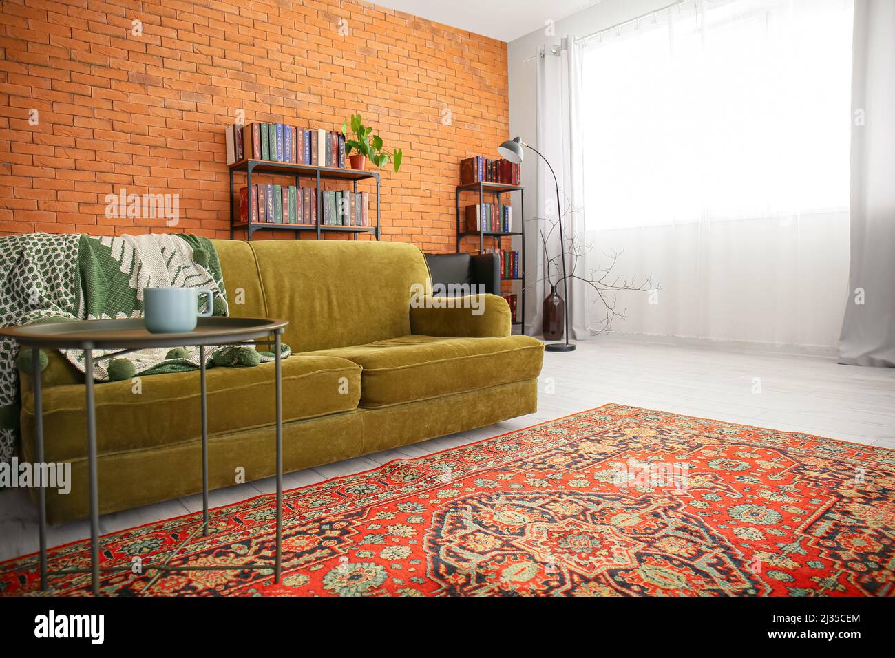 Interior of cozy living room with vintage carpet and green sofa Stock