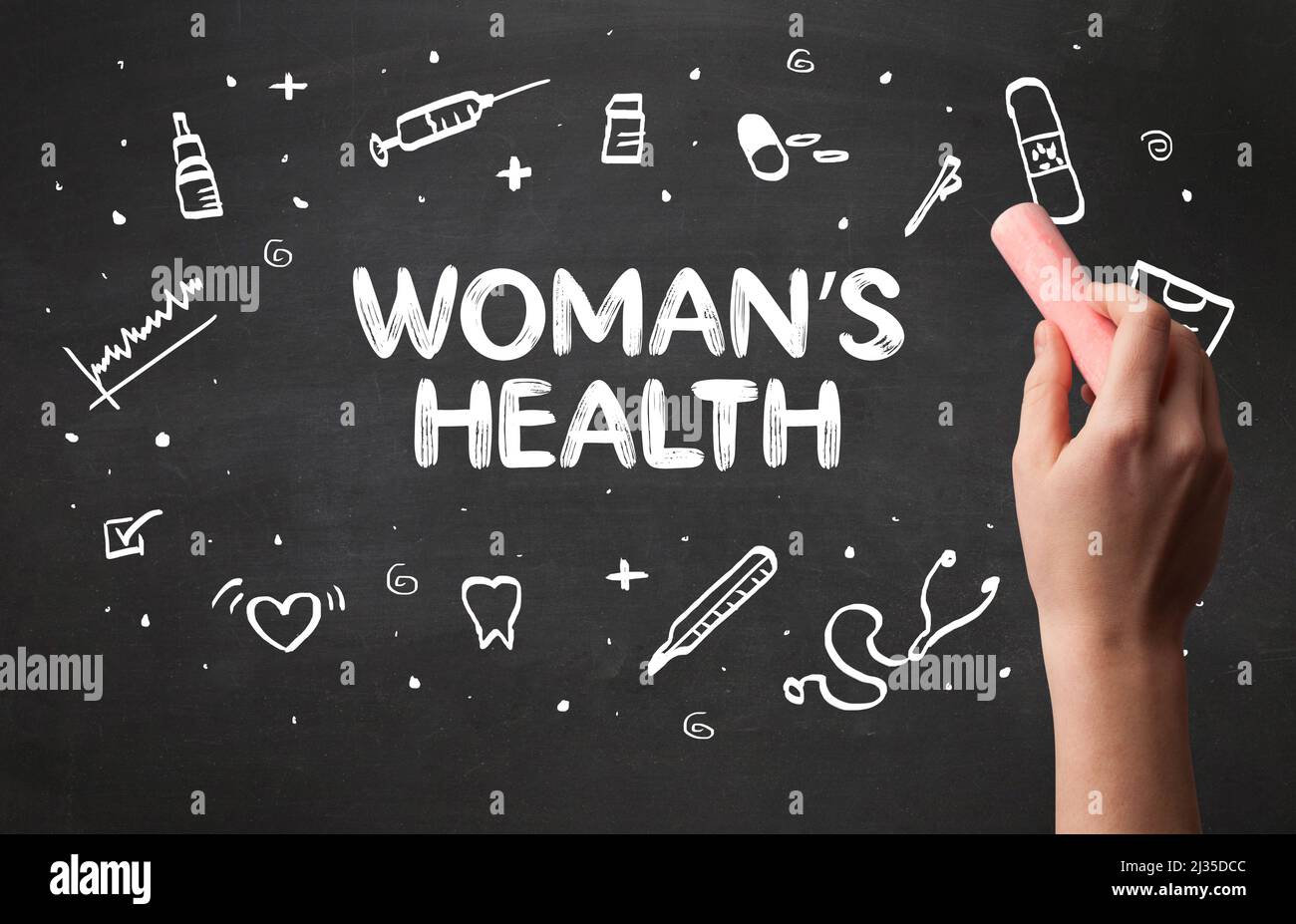 Hand drawing WOMAN'S HEALTH inscription with white chalk on blackboard