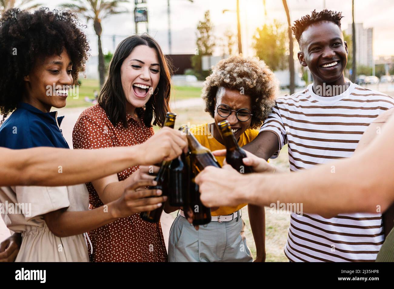 Happy young friends cheering with beer at summer party outdoors Stock Photo
