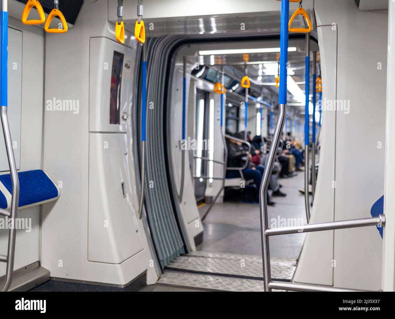 Public transport in the city. Moscow Metro. Yellow handrails for hands close-up. A full subway car lately in the evenings. There are a lot of people i Stock Photo