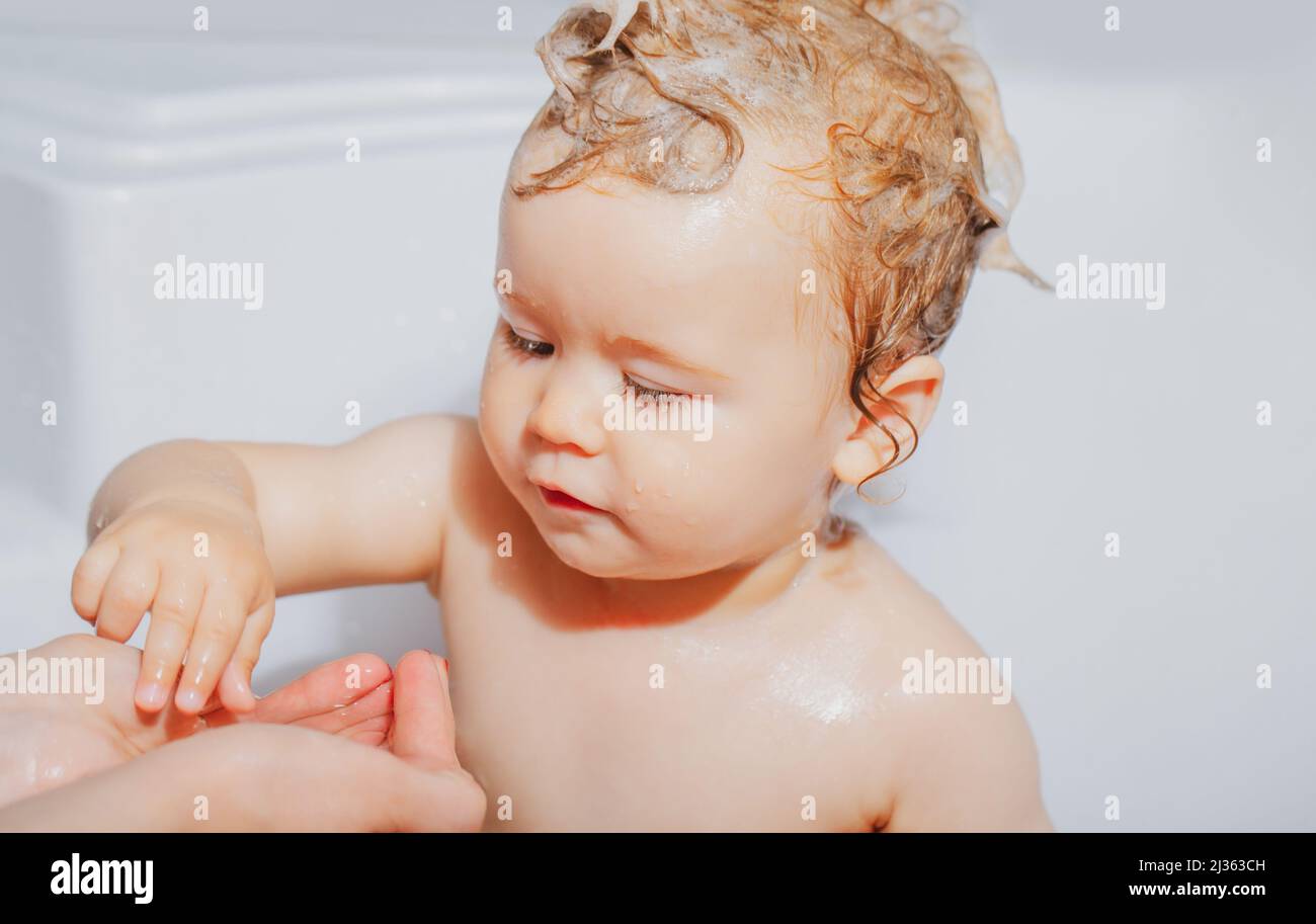 Child bathing. Baby showering. Portrait of kid bathing in a bath with