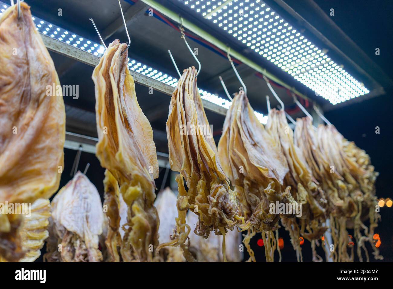 Traditional walking business selling dry squid on the street at night