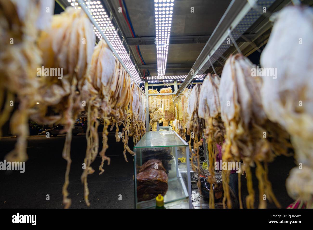 Traditional walking business selling dry squid on the street at night