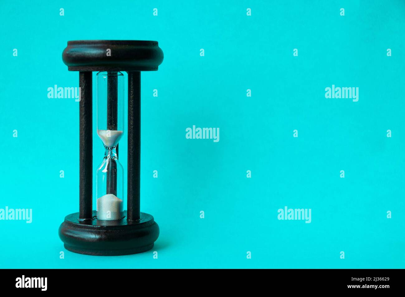 Minute glass isolated on light blue background. Copy space Stock Photo
