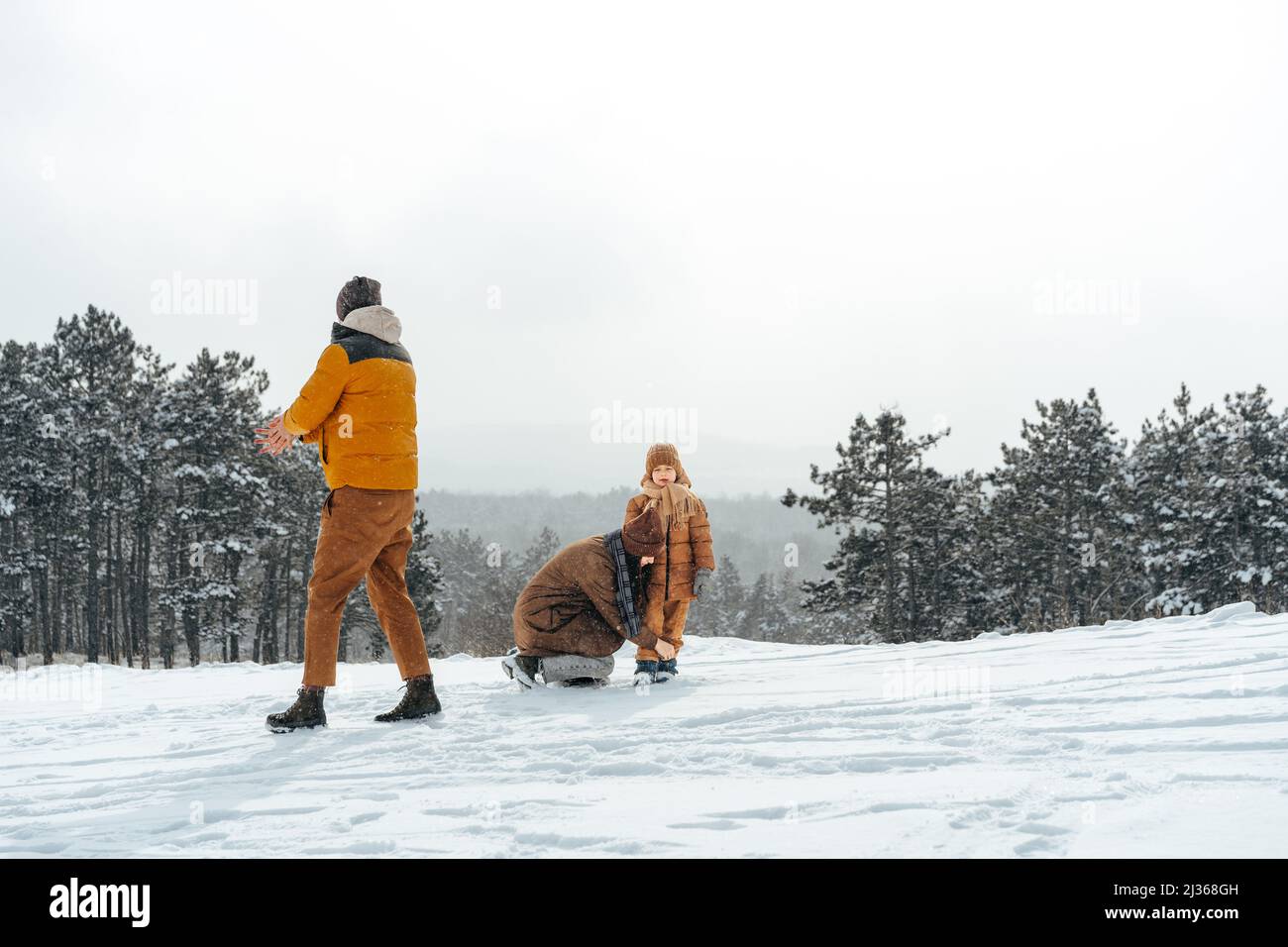 Happy family having a walk in winter outdoors in snow Stock Photo - Alamy
