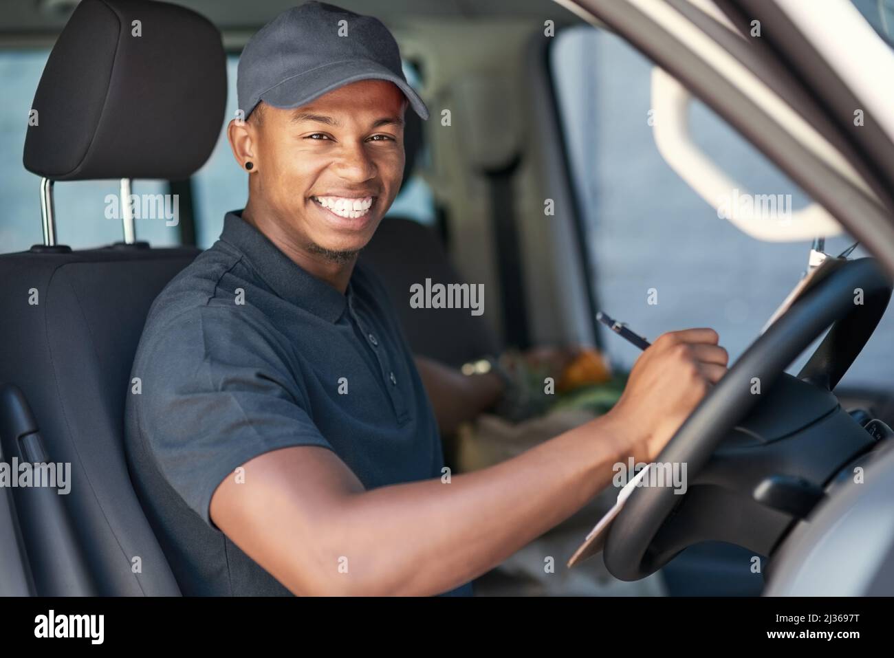 Going on his delivery rounds. Portrait of a courier writing on a ...