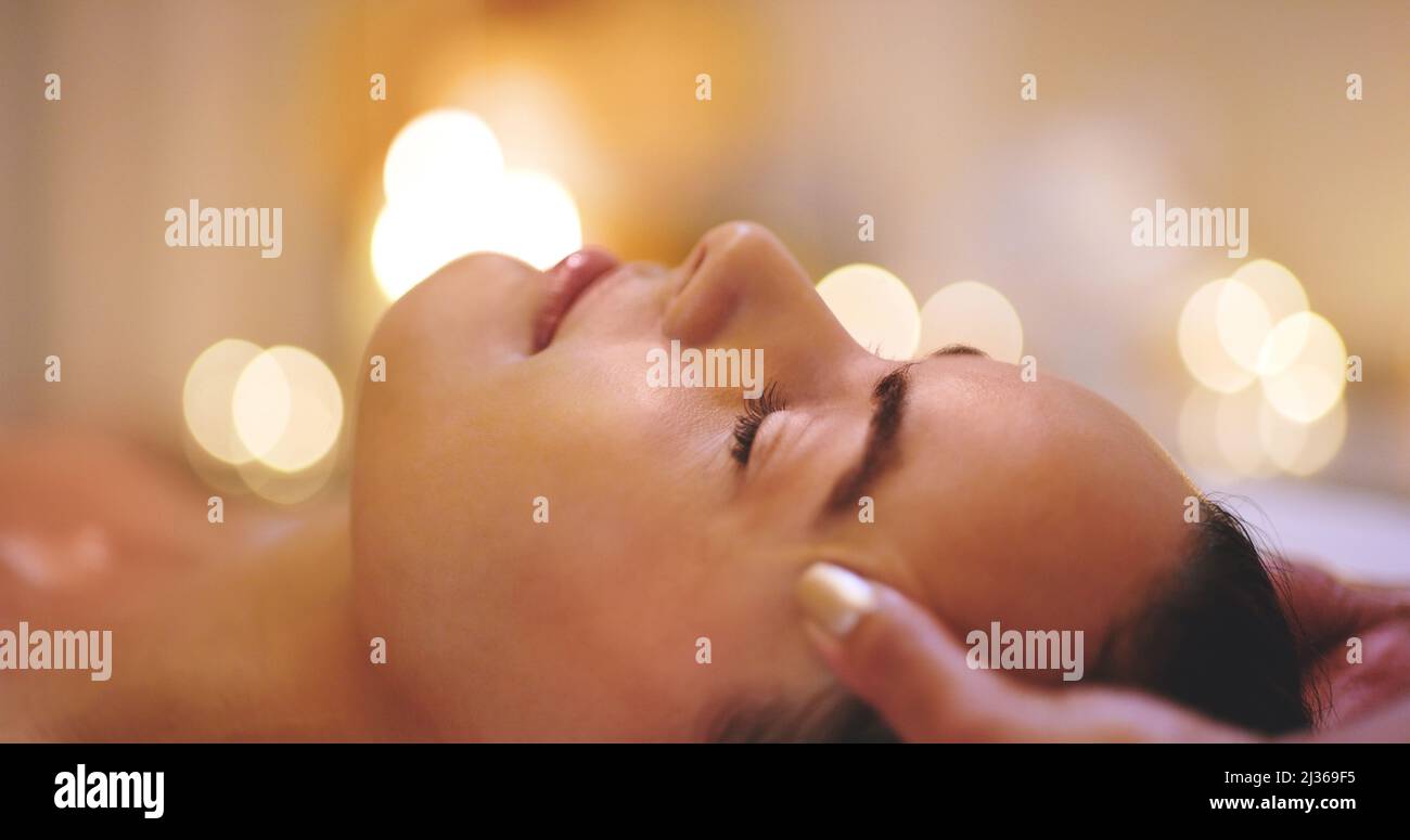 Getting rid of all the tension. Closeup shot of a beautiful young woman enjoying a head massage at a beauty spa. Stock Photo