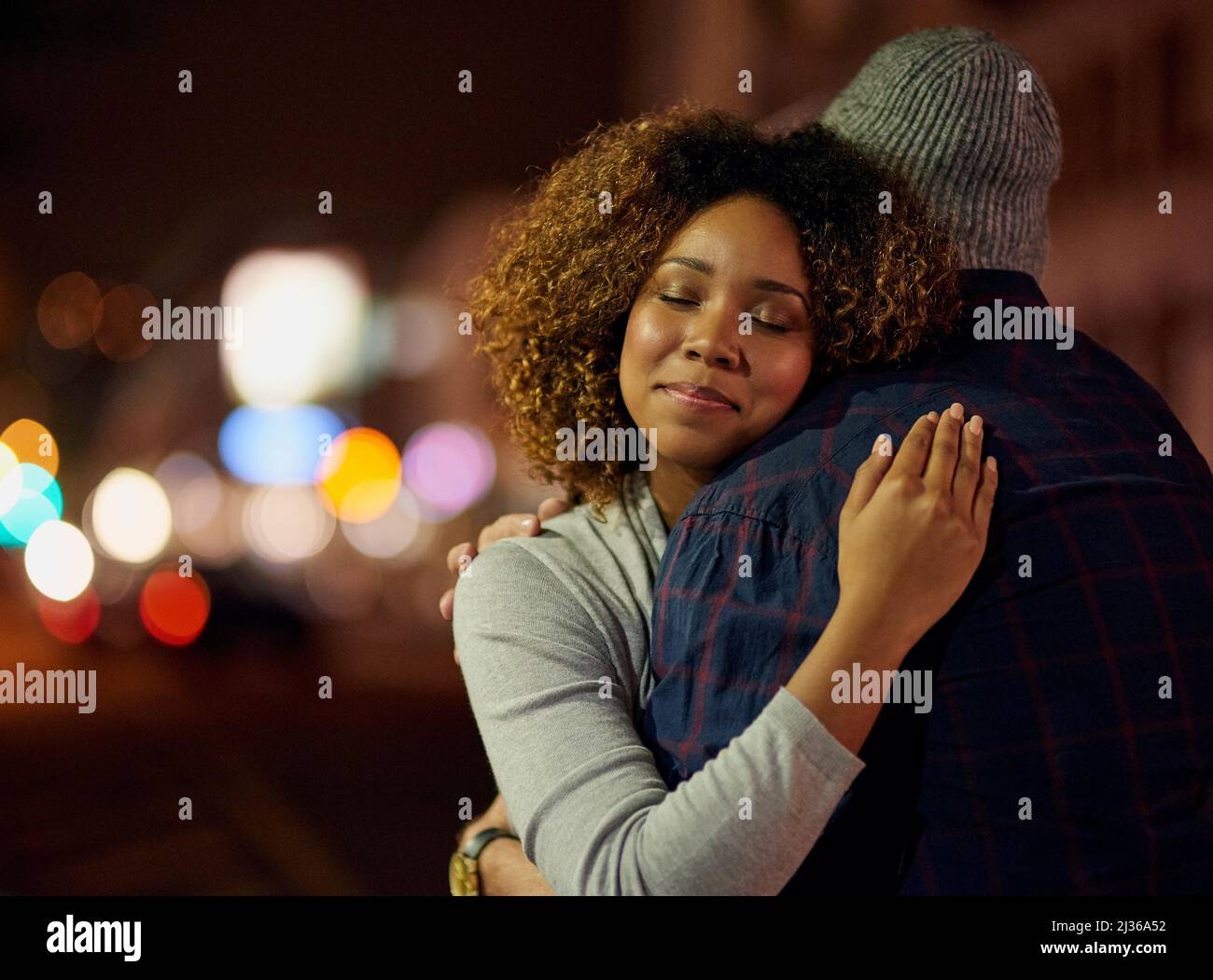 I feel so safe in his arms. Cropped shot of a young couple out on a date in the city. Stock Photo
