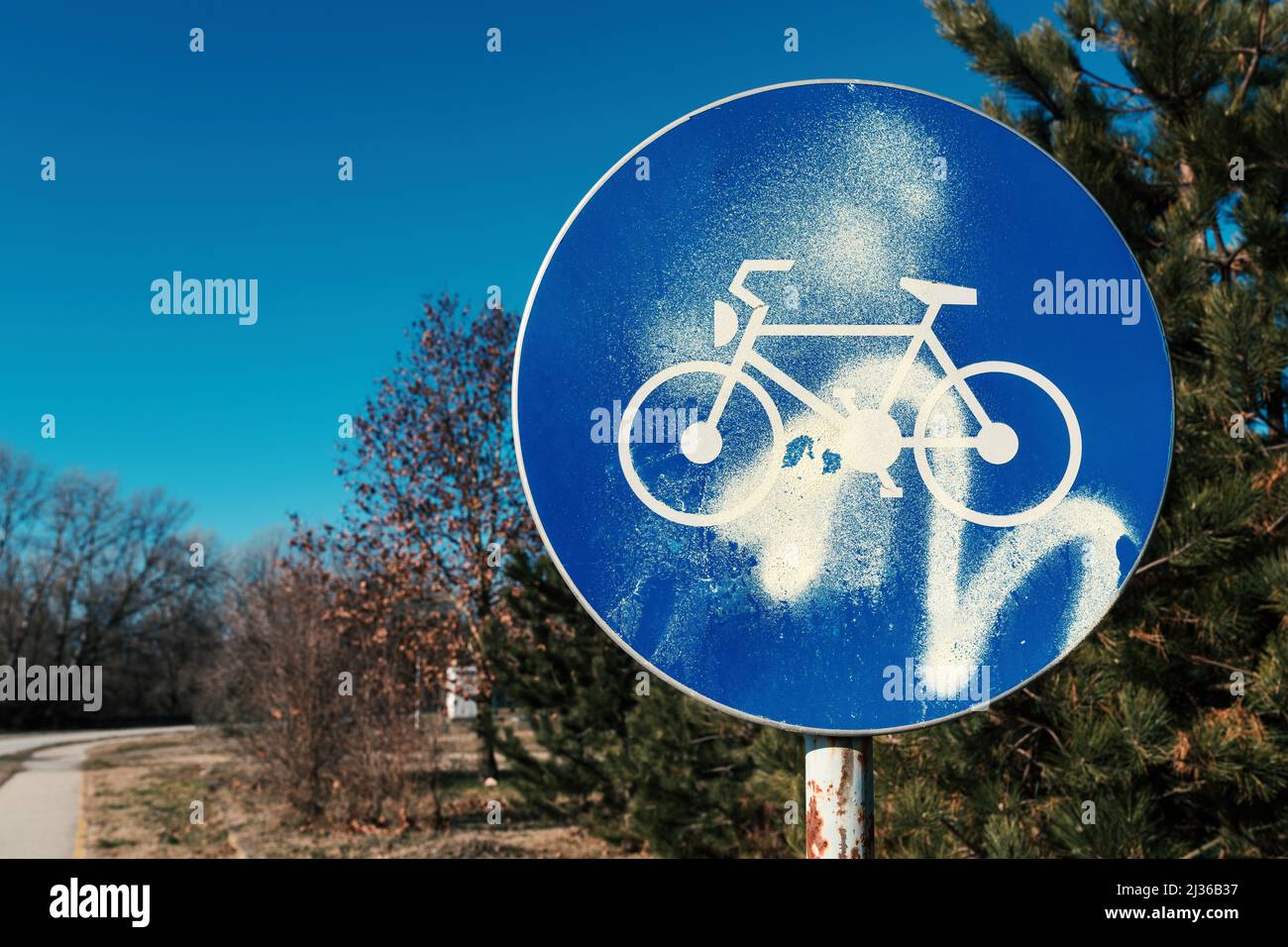 Bicycle lane or bike path sign sprayed with paint as act of vandalism