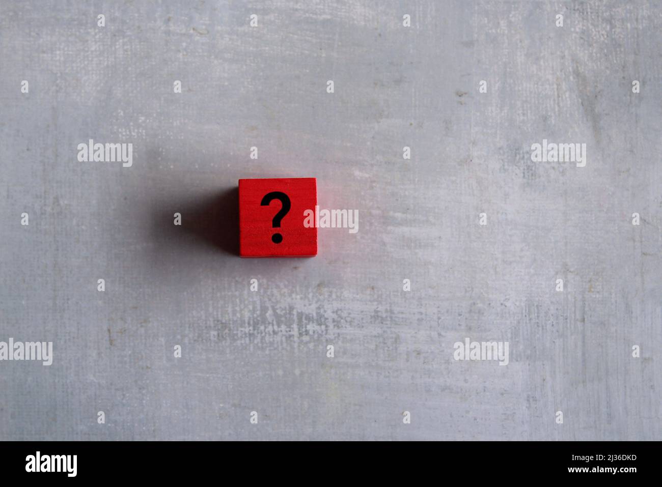 Red cubes with question mark on concrete background. Copy space for text. Ask, curious and doubt. Stock Photo