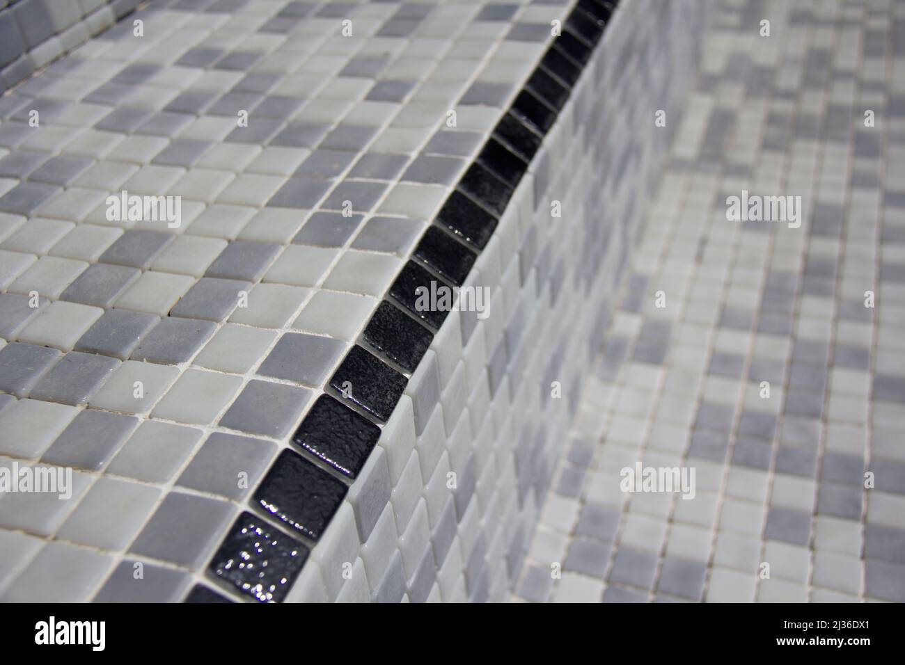 Black Stair edging tiles applied to refurbished swimming pool. Series of images taken during a Swimming pool refurbishment. Stock Photo