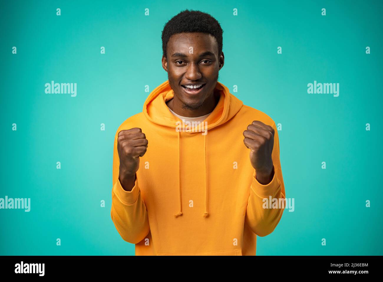 Portrait of overjoyed black man celebrating success in studio Stock Photo