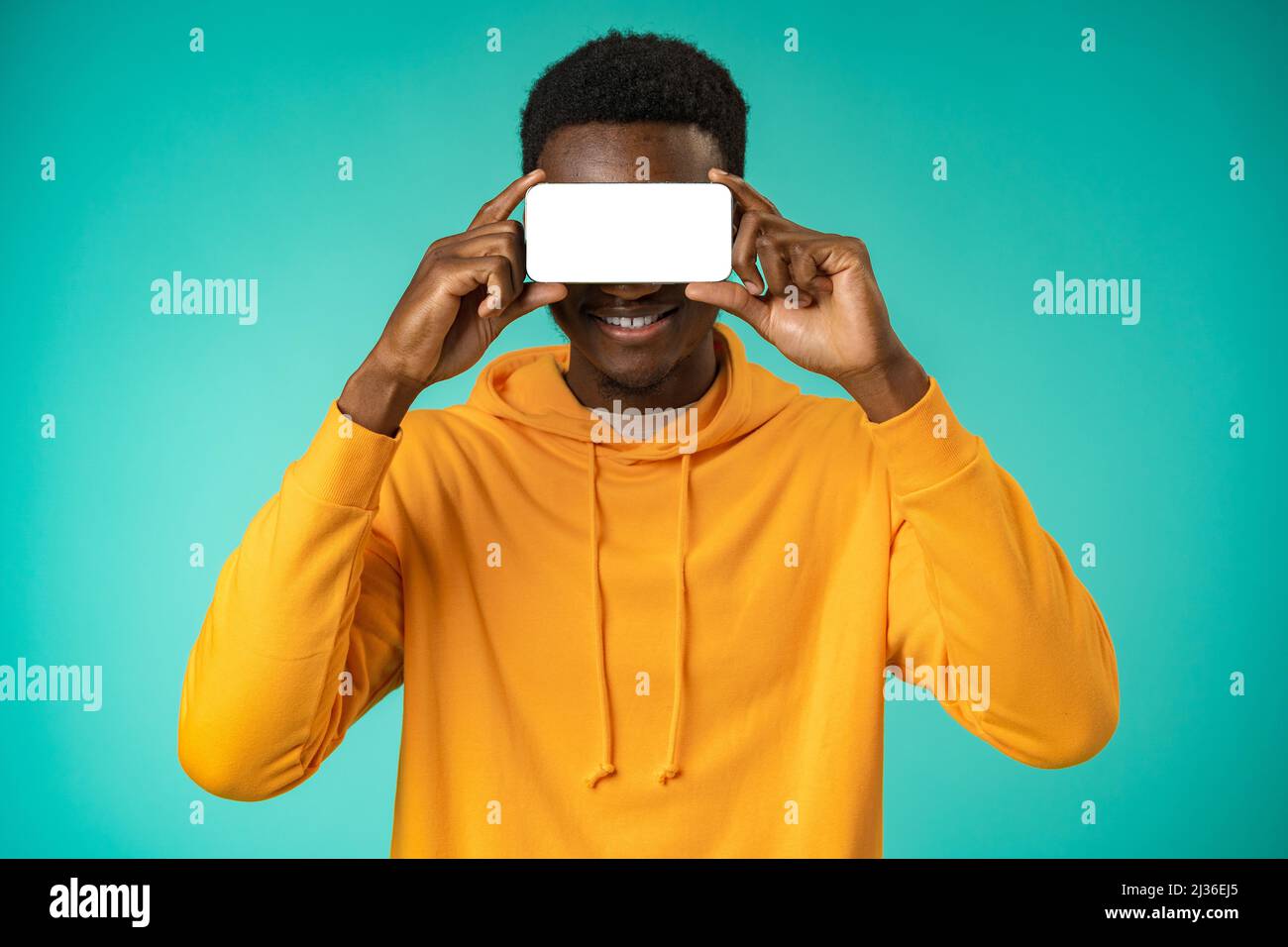 Young black man cover his face using phone in studio Stock Photo - Alamy