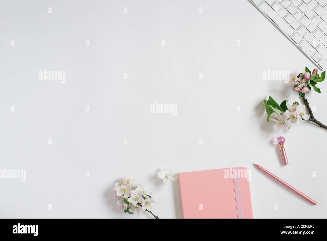 Blank paper notebook, pink flowers, golden stationery on marble