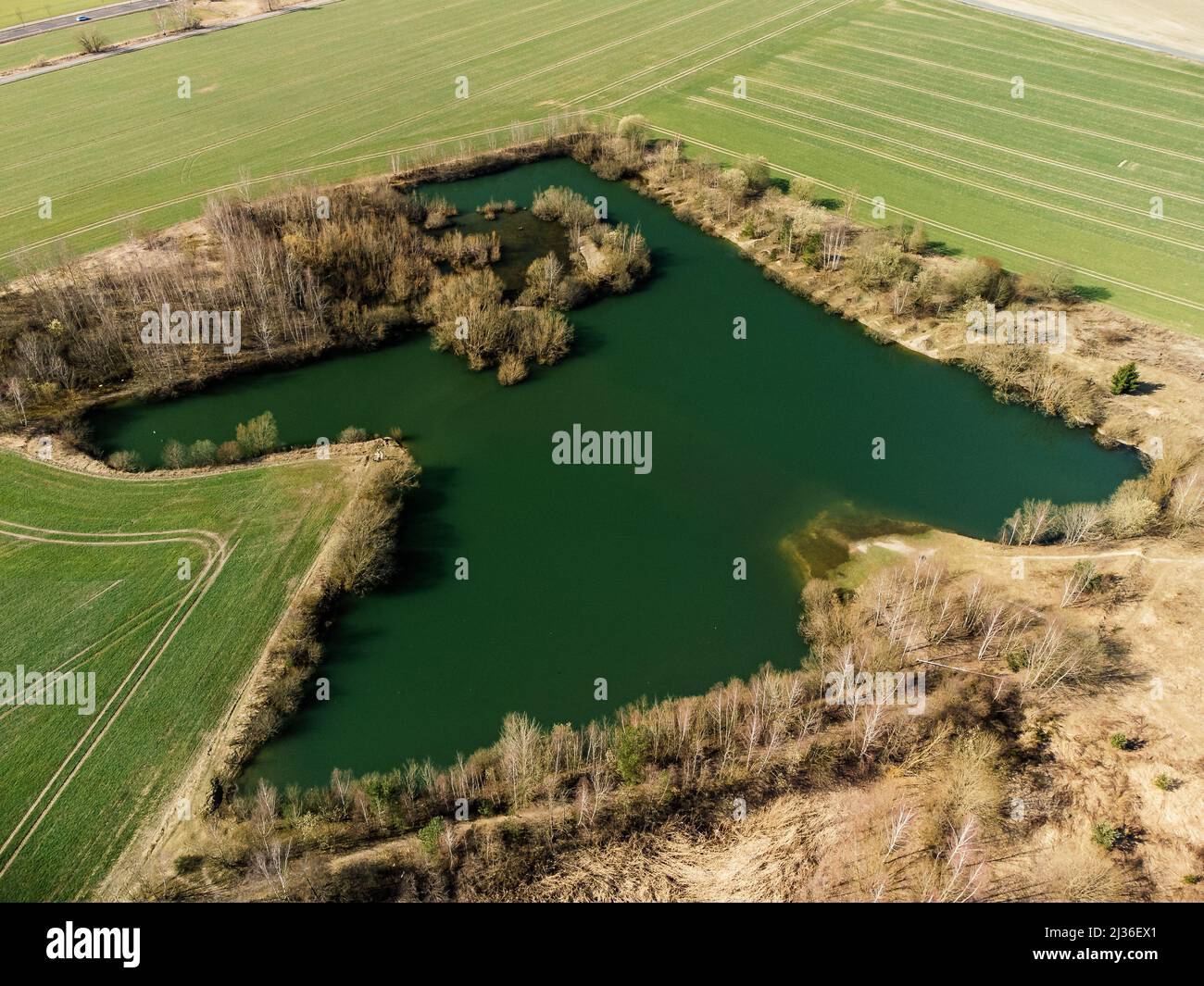 A Bird's-eye view of a small green lake surrounded by fields Stock ...