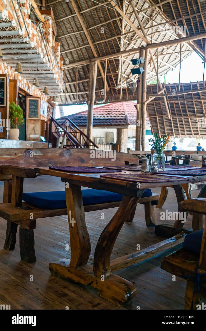 Wooden tables in cafe under a roof. Authentic interior of restaurant in