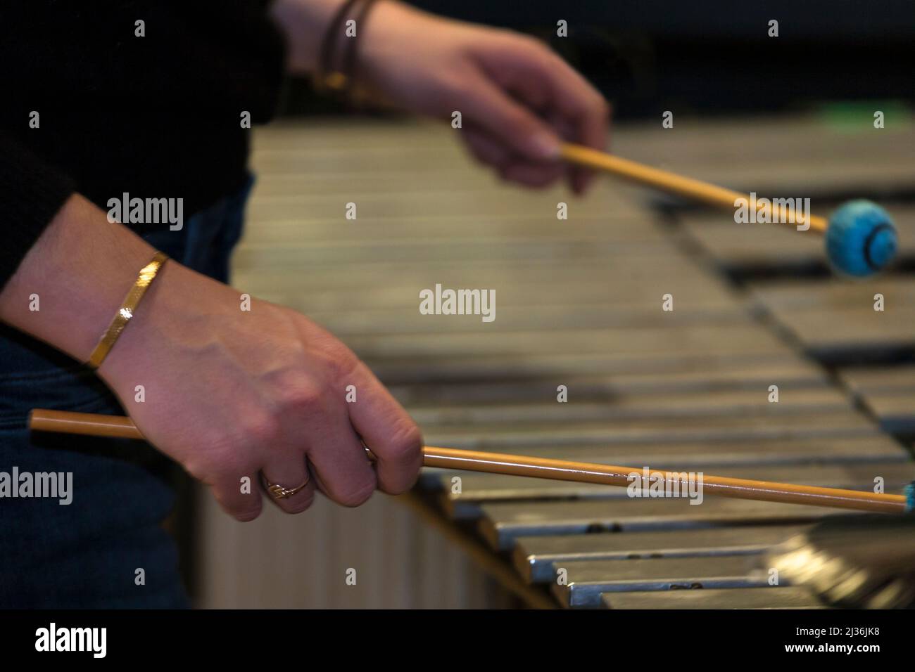 Close-up of a pair of musician's hands holding mallets whilst playing a ...
