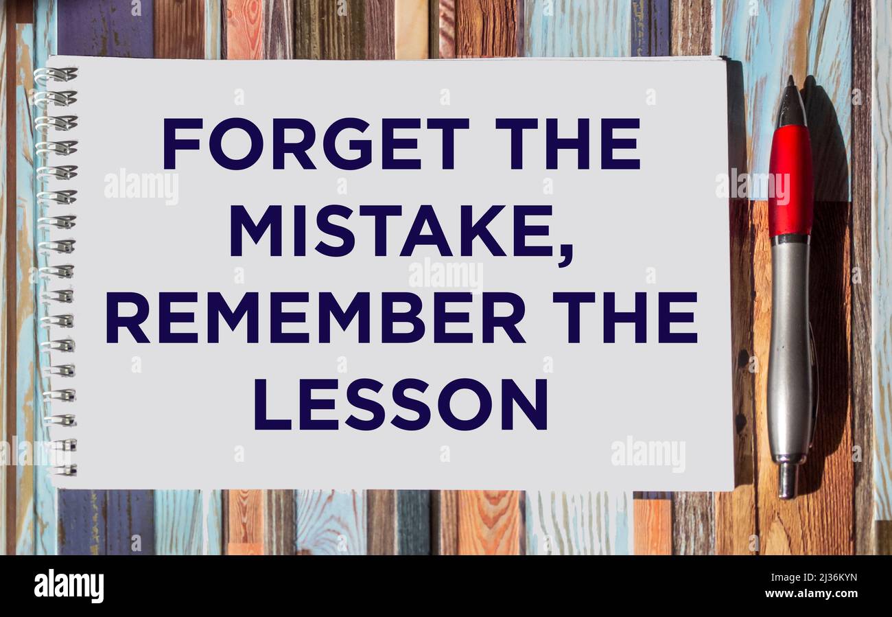 Motivational and inspirational quote - Forget the mistake, remember the lesson, written on a notepad on a striped background. Stock Photo