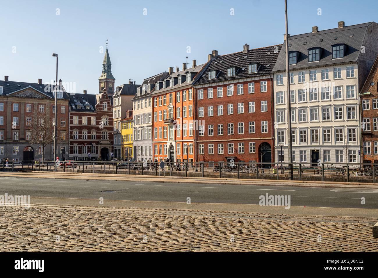 The bell tower of the city hall stands out among the colorful facades of the typical buildings of the old town of Copenhagen. Stock Photo