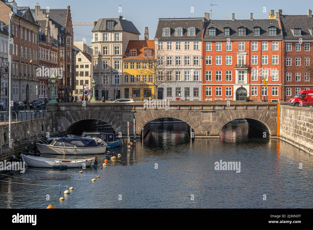 Colorful facades of typical houses in the old town of Copenhagen. In the foreground, the navigable canal that flows under the Storm Bridge. Denmark Stock Photo