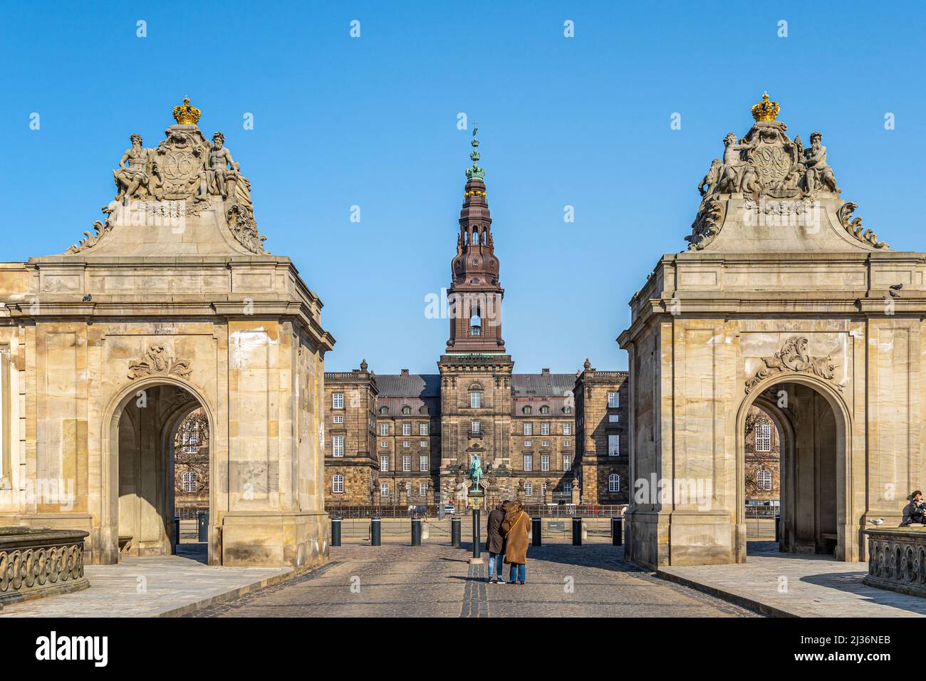 A couple of tourists visit Christiansborg Royal Palace on a sunny spring day. Slotsholmen, Copenhagen, Denmark, Stock Photo