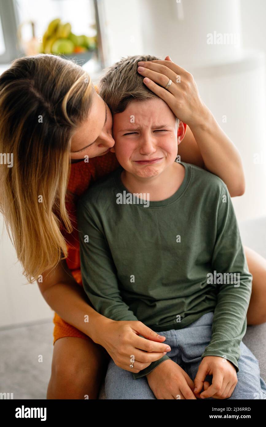 Portrait of mother consoling her crying sad injured son. Child family support parent concept Stock Photo