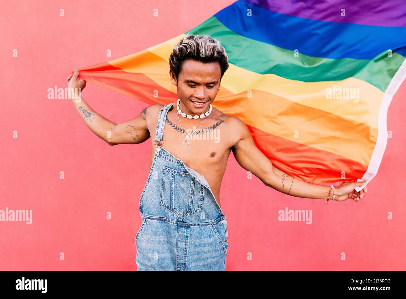 Happy guy with LGBT rainbow flag outdoors Stock Photo - Alamy