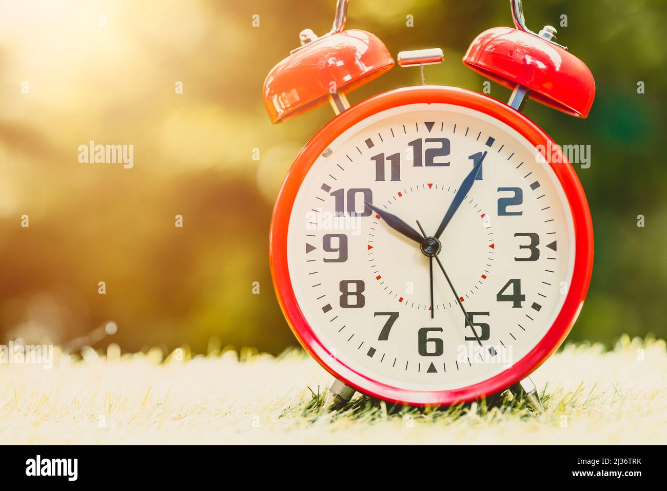 Alarm clock red Classic Vintage Retro Color Tone on Wood Table with Sun