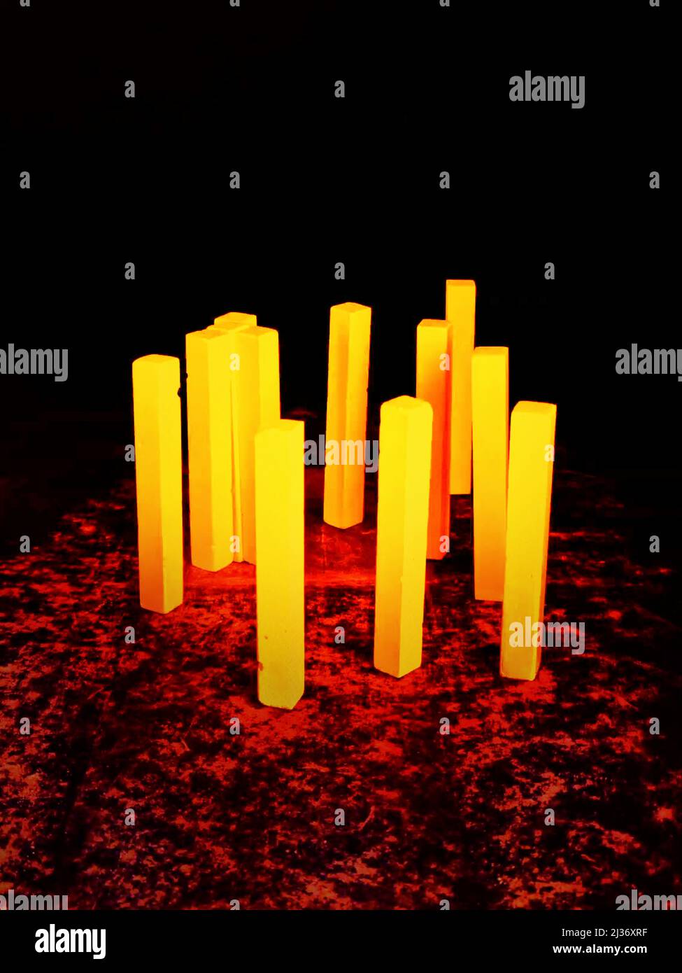 Yellow pillars on top of a rough and red floor on a black background Stock Photo Alamy
