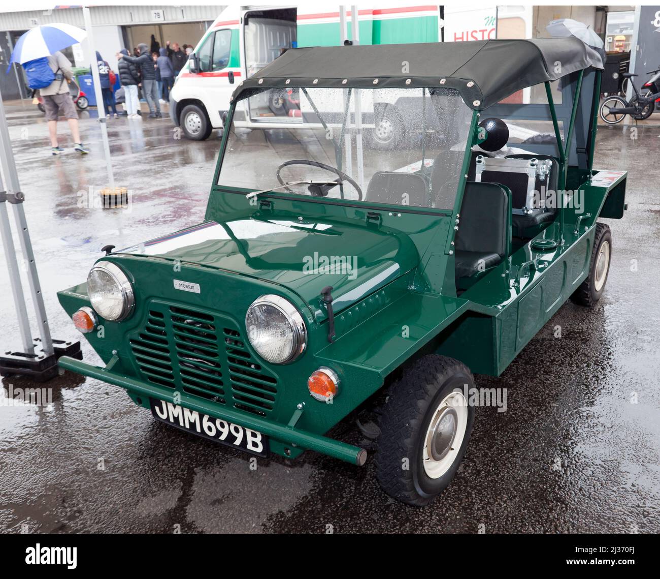 Three-Quarter Front view of a Green, 1964, Morris Mini Moke, undercover, in the National Paddock, at the 2021 Silverstone Classic Stock Photo