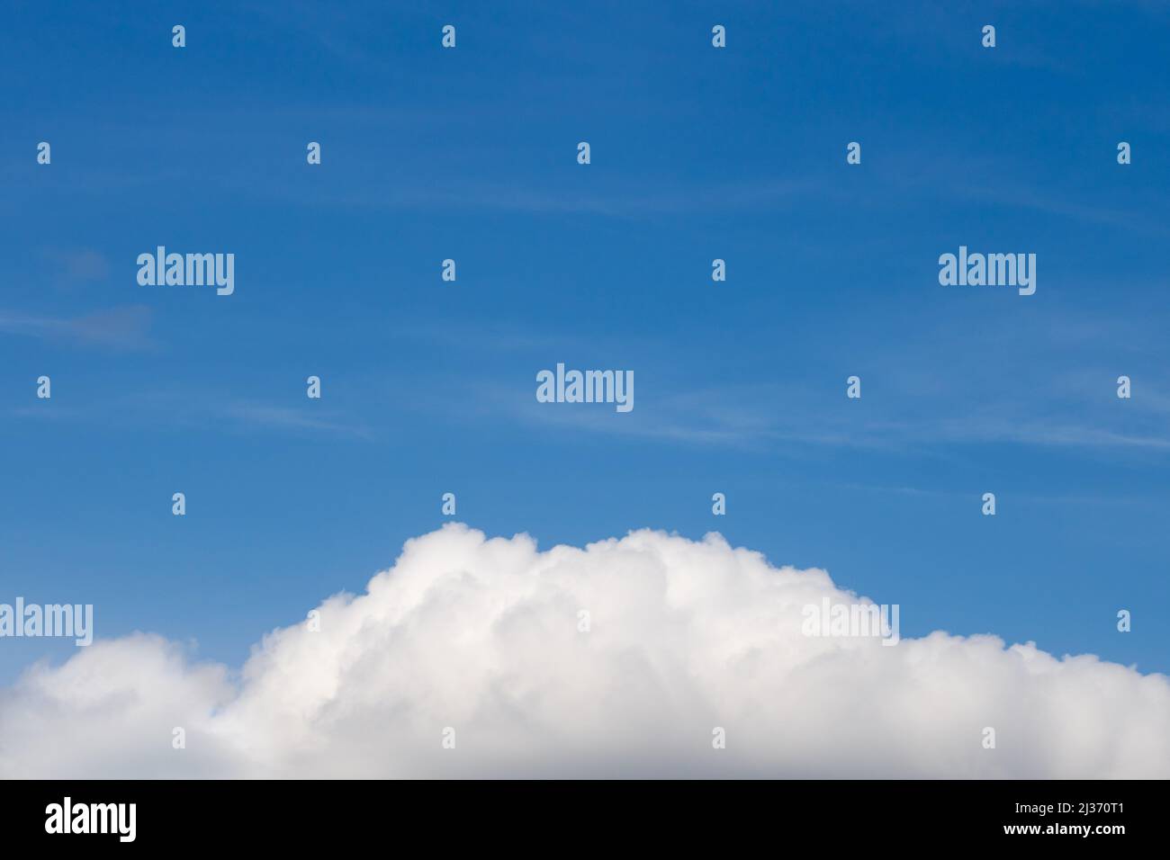 Fluffy white clouds at the bottom with the blue sky at the top. Sky background with empty space for text Stock Photo