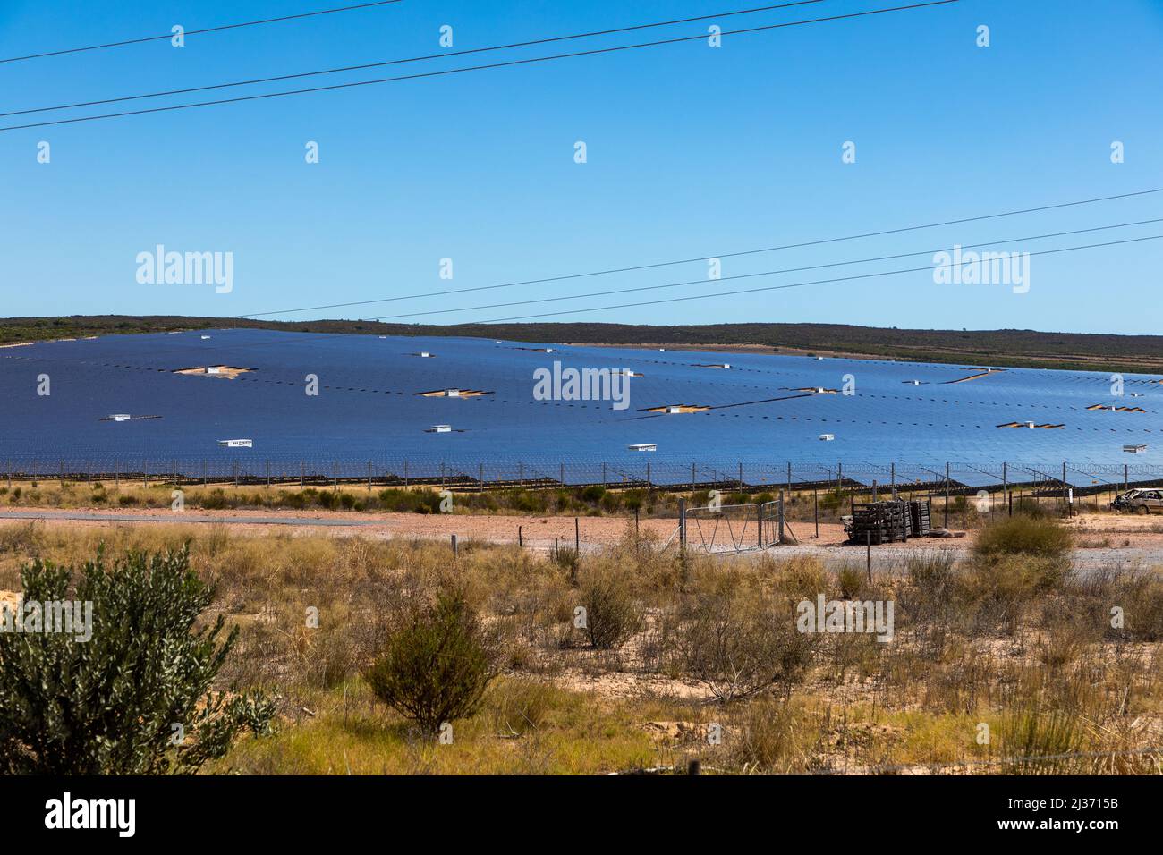 Semi desert area with a large selection of photovoltaic solar panels in the backgound. Clear blue sky Stock Photo