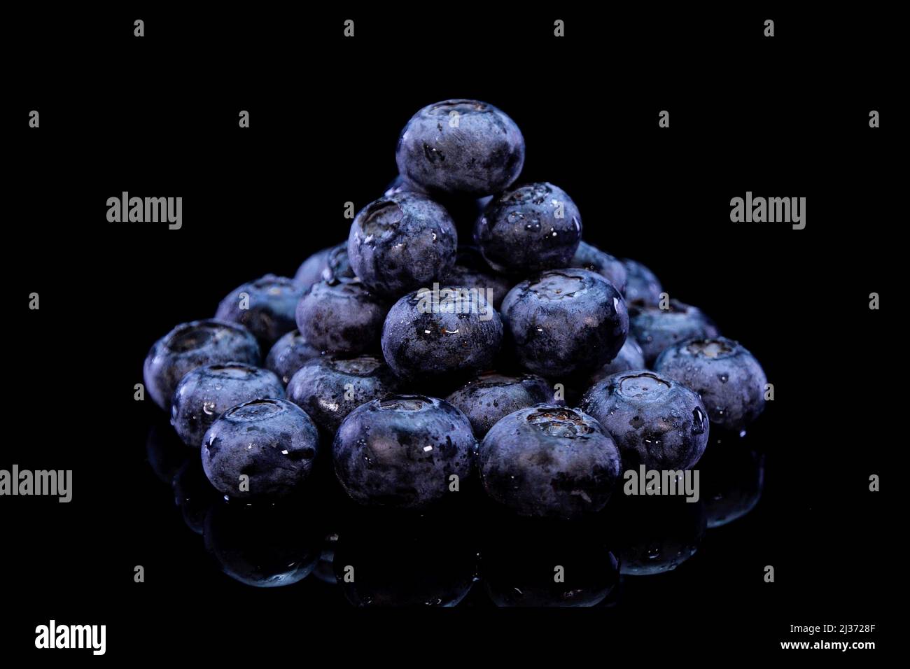 Blueberries on a black background. Fresh, firm and tasty berries. Raw vegan summer snacks, forest berries. Stock Photo